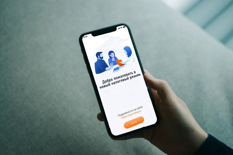 Фотография смартфона с открытым приложением «Мой налог» и надписью "Добро пожаловать в новый налоговый режим"